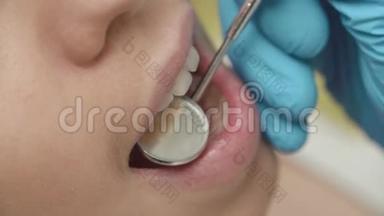 口腔和牙齿的检查。 在口腔检查过程中，病人年轻女孩张开嘴的特写。
